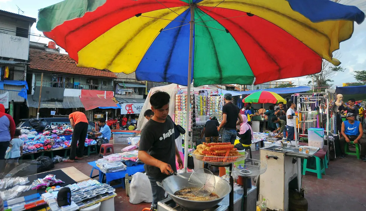 Pedagang menggoreng sosis saat berlangsungnya pasar malam di Petamburan, Jakarta, Selasa (10/1). Pasar malam menjadi alternatif belanja golongan menengah ke bawah. (Liputan6.com/Angga Yuniar)