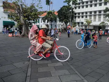 Pengunjung bersepeda mengelilingi kawasan Kota Tua, Jakarta, Sabtu (8/6/2019). Selama libur lebaran 2019, sejak 7 Juni kemarin hingga beberapa hari kedepan, jam berkunjung ke berbagai museum di kawasan wisata sejarah Kota Tua diperpanjang hingga pukul 20.00 WIB. (Liputan6.com/Faizal Fanani)