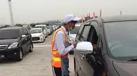 Petugas Tol Cipali saat melayani pembayaran tol di Gerbang Tol Palimanan. (Liputan6.com/Panji Prayitno)