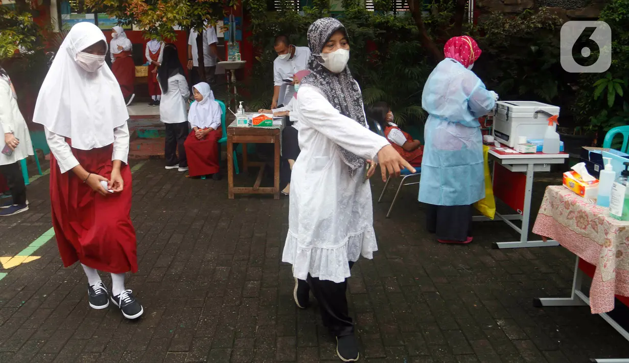Petugas kesehatan mengarahkan siswa saat tes usap PCR di SDN Sudimara Barat 5, Kota Tangerang, Rabu (12/1/2022). Tes usap dilakukan untuk mengantisipasi penyebaran COVID-19 di sekolah setelah dimulainya pembelajaran tatap muka kapasitas kelas 100 persen di Kota Tangerang. (Liputan6.com/Angga Yuniar)
