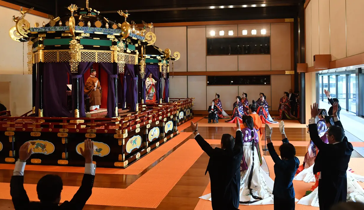 Perdana Menteri Jepang Shinzo Abe (kanan) bersorak 'banzai' kepada Kaisar Naruhito (kiri atas) dan Permaisuri Masako dalam upacara penobatan di Istana Kekaisaran, Tokyo, Jepang, Selasa (22/10/2019). Naruhito resmi menjadi Kaisar Jepang setelah ritual penobatan. (Kazuhiro Nogi/Pool Photo via AP)