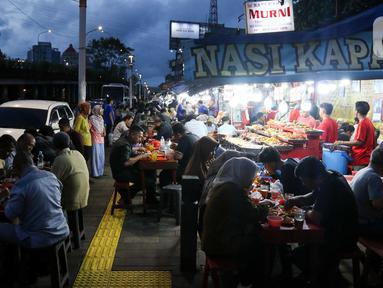 Warga menikmati waktu serta menu berbuka puasa di Sentra Kuliner Nasi Kapau di Jalan Kramat Raya, Senen, Jakarta, Senin (17/3/2025). (Liputan6.com/Herman Zakharia)