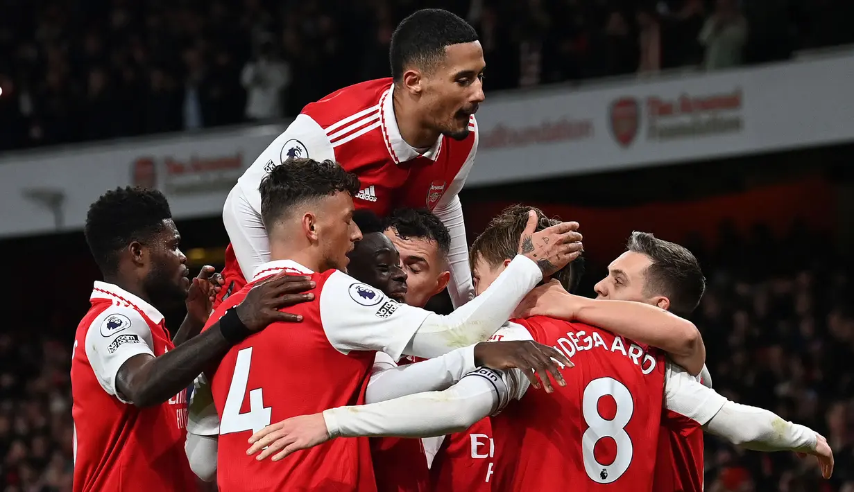 Pemain Arsenal berselebrasi setelah Martin Odegaard mencetak gol ketiga timnya ke gawang Everton pada laga lanjutan Liga Inggris 2022/2023 yang berlangsung di Emirates Stadium, London, Kamis (02/03/2023) WIB. Arsenal berhasil menang telak dengan skor 4-0. (AFP/Glyn Kirk)