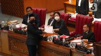 Menteri Dalam Negeri Tito Karnavian menyerahkan berkas laporan Pemerintah terkait tiga Rancangan Undang-Undang (RUU) Pemekaran Provinsi Papua kepada Ketua DPR RI Puan Maharani dalam rapat paripurna ke-26 masa persidangan V tahun 2021-2022 di Kompleks Parlemen, Senayan, Jakarta, Kamis, (30/6/2022). (Liputan6.com/Angga Yuniar)
