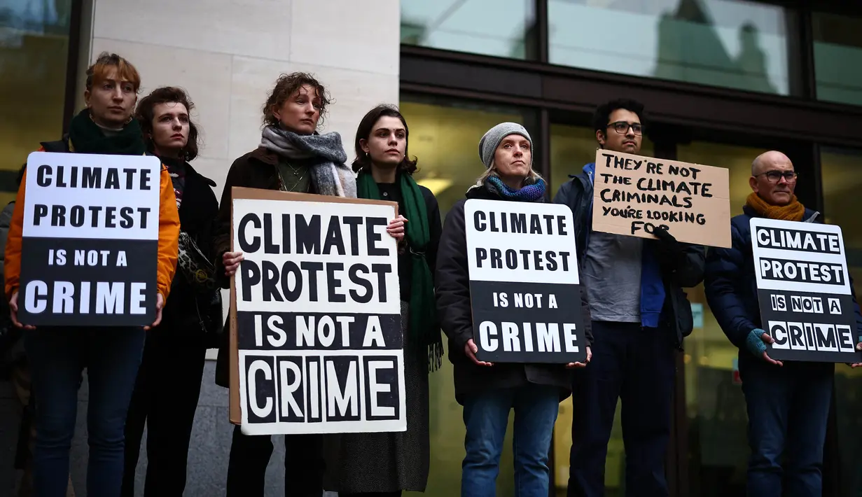 Para pengunjuk rasa berdiri dengan membawa plakat di luar Pengadilan Westminster Magistrates di London pada tanggal 2 Februari 2024. (HENRY NICHOLLS/AFP)