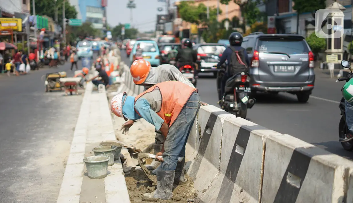 Pekerja menyelesaikan pembuatan separator jalan di kawasan Pasar Minggu, Jakarta Selatan, Rabu (23/10/2019). Pembuatan separator permanen tersebut merupakan bagian dari penataan kawasan Pasar Minggu agar lebih tertata dengan rapi. (Liputan6.com/Immanuel Antonius)