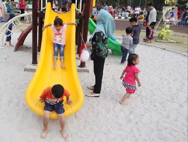 Anak-anak bermain seluncur di Lapangan Banteng, Jakarta, Minggu (14/10). Lapangan Banteng semakin ramai dikunjungi pada hari Minggu. (Liputan6.com/JohanTallo)