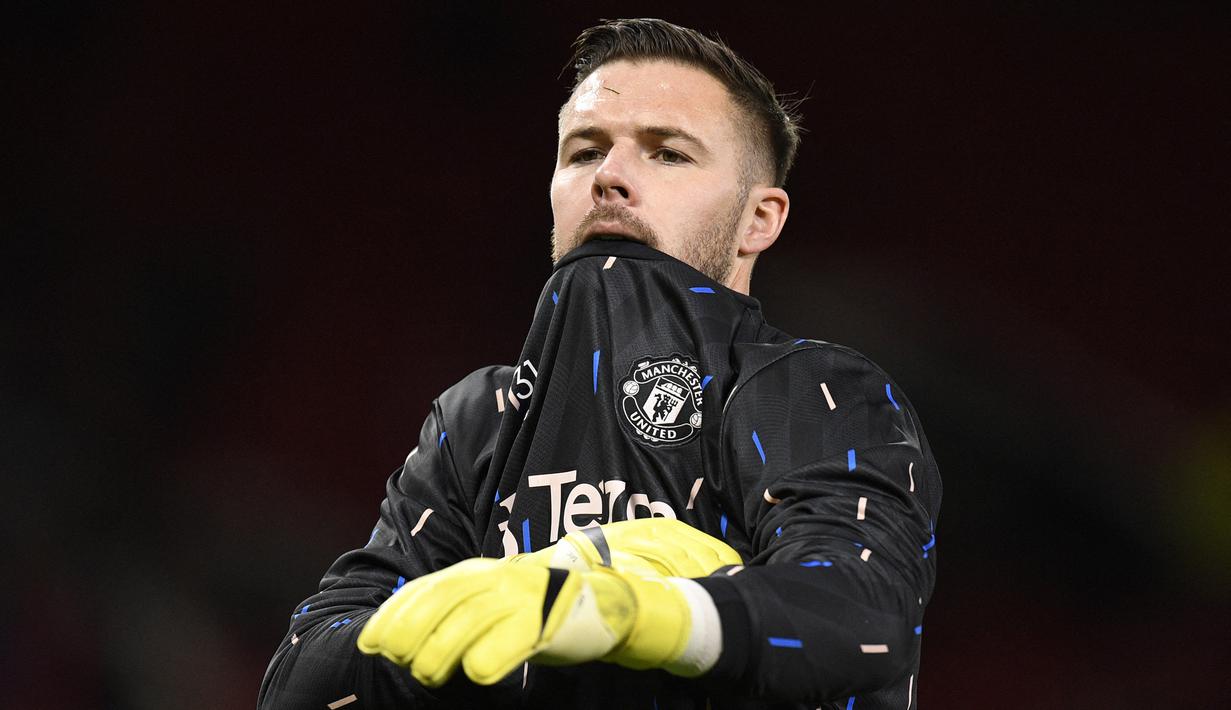 Kiper Manchester United, Jack Butland melakukan pemanasan jelang laga perempatfinal Piala Liga 2022/2023 menghadapi Charlton Athletic di Old Trafford Stadium, Manchester (10/1/2023). Didatangkan dengan status pinjaman selama setengah musim dari Crystal Palace pada Januari 2023 untuk melapis David De Gea, Jack Butland nyatanya hingga kini belum pernah sekalipun dimainkan pelatih Erik ten Hag. Besar kemungkinan ia akan dikembalikan ke Crystal Palace akhir musim ini. (AFP/Oli Scarff)