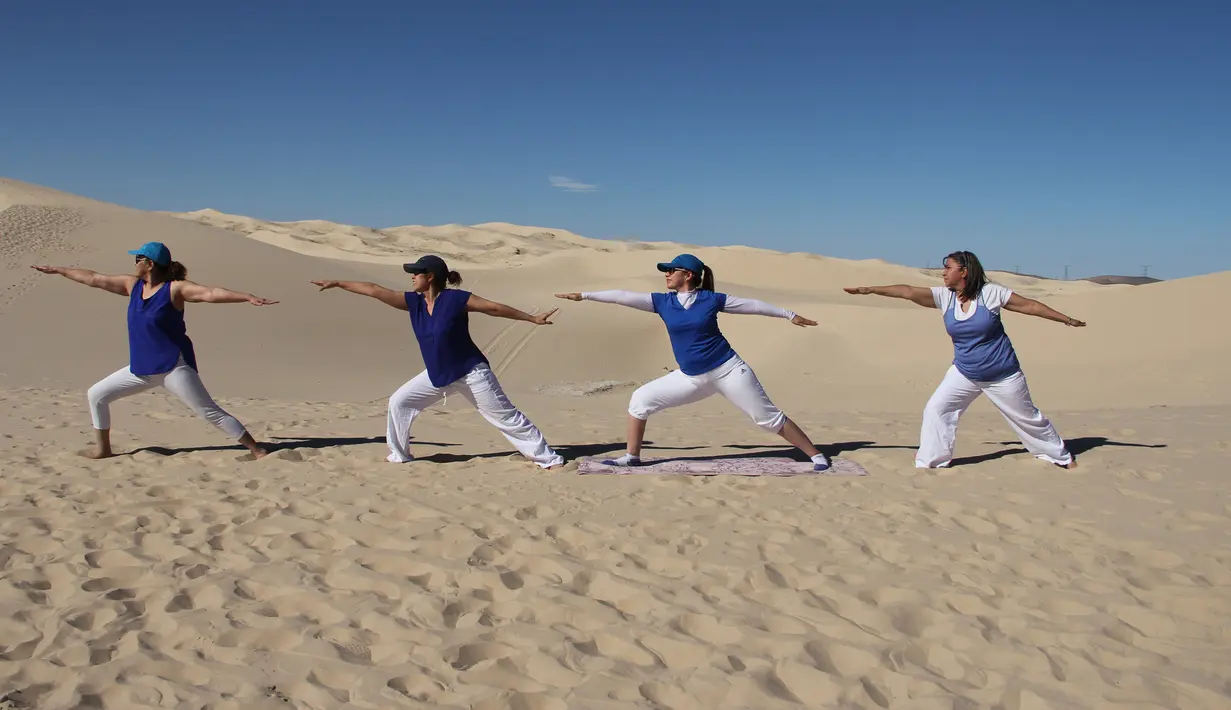 Peserta menghadiri kelas yoga yang diselenggarakan oleh komunitas YSYoga System di gurun Samalayuca, negara bagian Chihuahua, Meksiko pada 25 Mei 2019. Ratusan penggemar yoga mengikuti latihan bersama di bawah terik matahari dan beralaskan pasir. (Herika MARTINEZ/AFP)