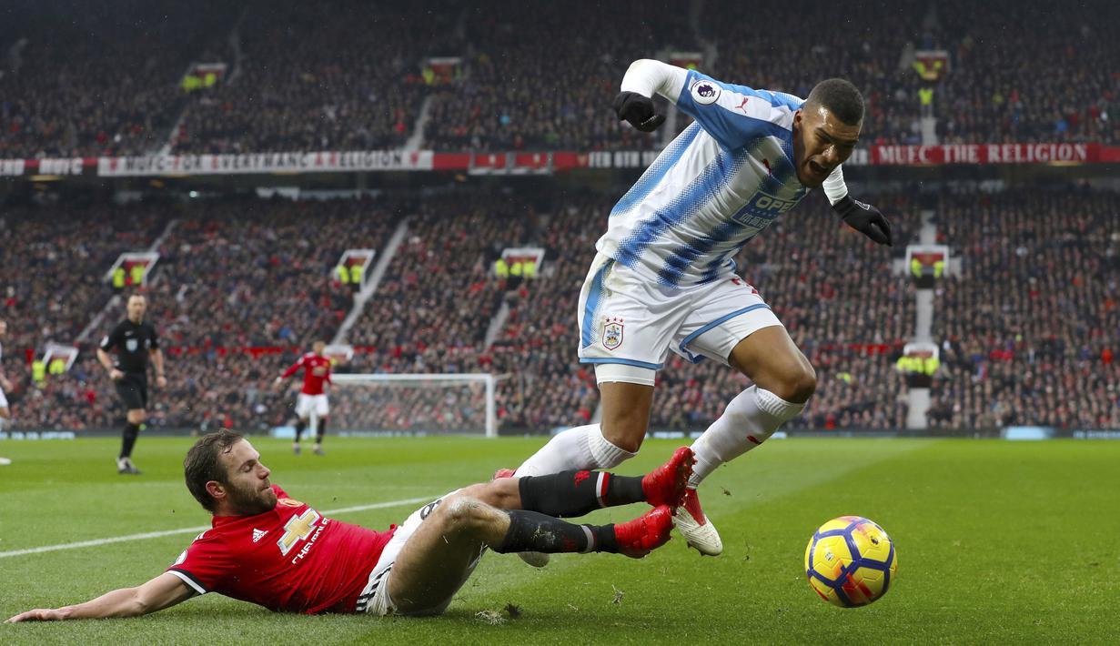 Pemain Manchester United, Juan Mata menghalau bola dari kaki pemain Huddersfield Town, Collin Quaner pada laga Premier League di Old Trafford, Manchester, (3/2/2018). MU menang 2-0. (Martin Rickett/PA via AP)
