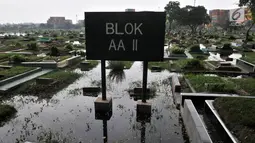 Kondisi ratusan makam yang terendam banjir di TPU Semper, Jakarta, Selasa (4/12). TPU Semper menjadi langganan banjir saat musim penghujan akibat rendahnya permukaan tanah dengan ketinggian air sepinggang orang dewasa. (Merdeka.com/Iqbal S. Nugroho)