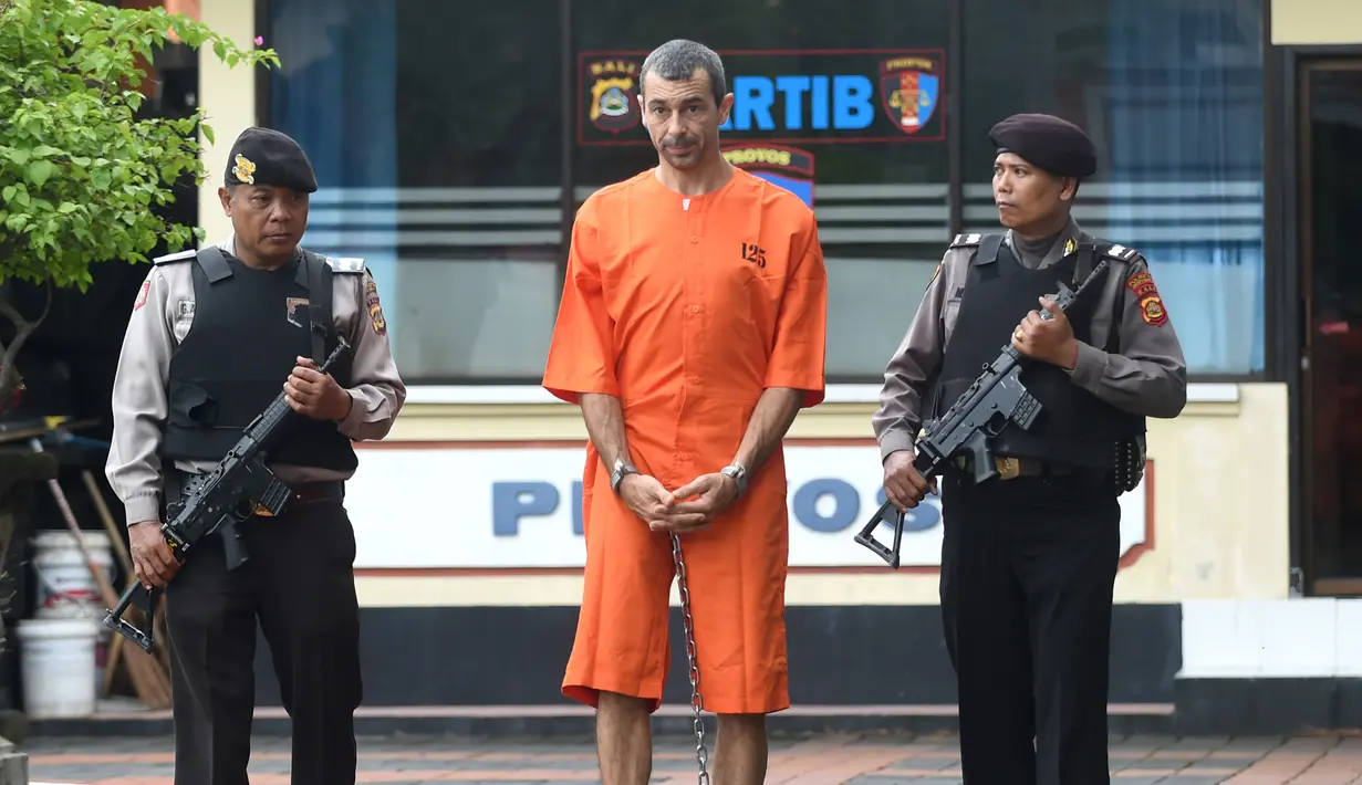 Warga negara Prancis Samuel Pierre Danguny dikawal dua polisi sebelum konferensi pers di kantor polisi di Denpasar, Bali (18/3). Danguny ditangkap pada 15 Maret dengan kepemilikan 33 gram ganja dan 2 paket Hasis 16 gram. (AFP Photo/Sonny Tumbelaka)