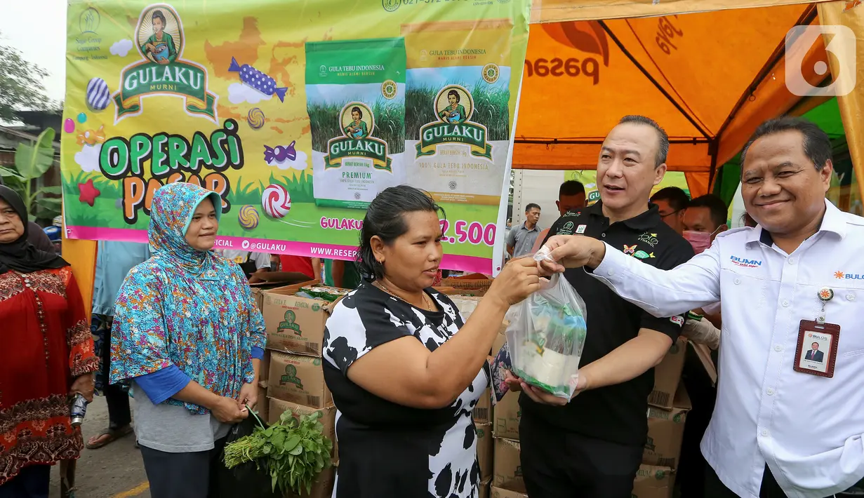 Direktur Operasi dan Pelayanan Publik Perum Bulog Tri Wahyudi Saleh didampingi Direktur Sugar Group Companies Irwan Ang menjual gula pasir kepada warga pada Operasi Pasar di Pasar Inpres Kramat Jati, Jakarta (18/3/2020). Setiap orang dibatasi pembeliannya maksimal 2 kg. (Liputan6.com/Fery Pradolo)