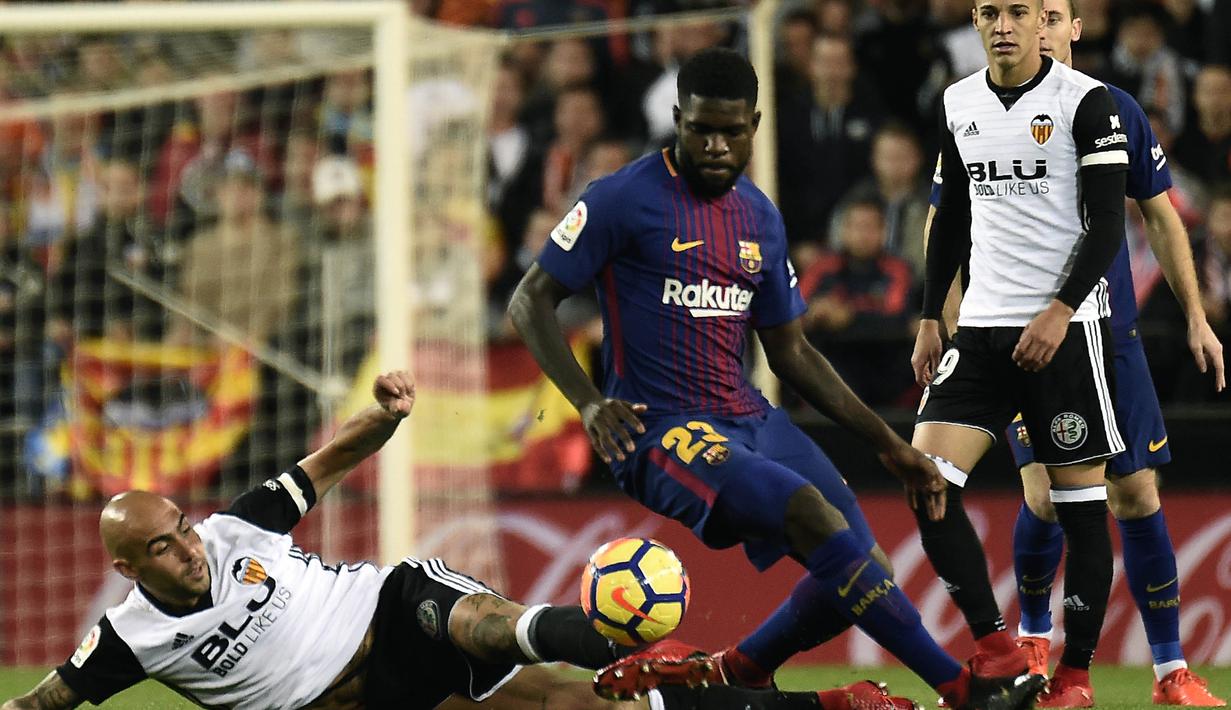 Bek Barcelona, Samuel Umtiti, berebut bola dengan striker Valencia, Simone Zaza, pada laga La Liga Spanyol di Stadion Mestalla, Valencia, Minggu (26/11/2017). Kedua klub bermain imbang 1-1. (AFP/Jose Jordan)