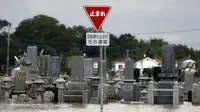 Sebuah pemakaman terendam air akibat meluapnya sungai Kinugawa yang disebabkan Topan Etau di Joso, Ibaraki Prefecture, Jepang, Sabtu (12/9/2015). Tim evakuasi terus melakukan pencarian terhadap warga yang terkena dampak Topan Etau.  (REUTERS/Issei Kato)