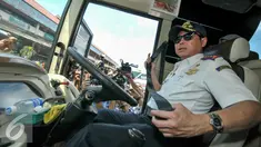 Menteri Perhubungan, Ignasius Jonan memeriksa sabuk pengaman bus pengemudi yang tidak berfungsi, Jakarta, Jumat (24/6). Menhub Jonan tinjau kesiapan Terminal Kampung Rambutan jelang arus mudik. (Liputan6.com/Yoppy Renato)