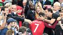 Striker Portugal, Cristiano Ronaldo, dipeluk seorang pendukung Portugal setelah meraih gelar juara Piala Eropa 2016 di Stade de France, Saint-Denis, Senin (11/7/2016) dini hari WIB. (AFP/Franck Fife)