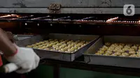 Pekerja saat memanggang kue kering di sebuah industri rumahan di Kawasan Kwitang, Jakarta, Jumat (30/4/2021). Tahun ini produksi kue kering menjelang lebaran mulai meningkat namun masih mengalami penurunan produksi hingga separuhnya dibandingkan dengan sebelum pandemi. (Liputan6.com/Faizal Fanani)