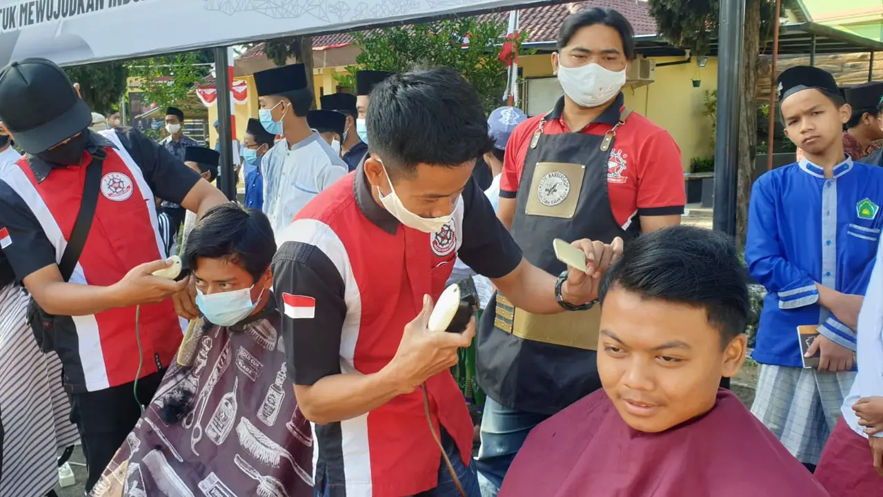 Para tukang cukur handal Persaudaraan Pemangkas Rambut Garut (PPRG) nampak asik memberikan pelayanan cukur gratis kepada 76 anak yatim dalam puncak perayaan HUT Bhayangkara di Garut. (Liputan6.com/Jayadi Supriadin)