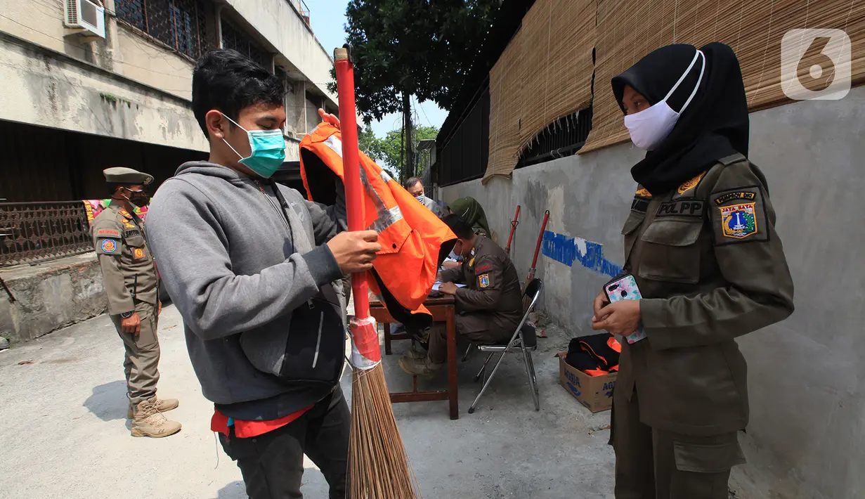 Petugas Satpol PP menghukum warga yang terjaring razia masker di kawasan Tanjung Duren, Jakarta, Kamis (19/11/2020). Satpol PP terus menindak warga yang melanggar protokol kesehatan selama PSBB transisi dengan sanksi kerja sosial di sarana umum atau membayar denda. (merdeka.com/Imam Buhori)