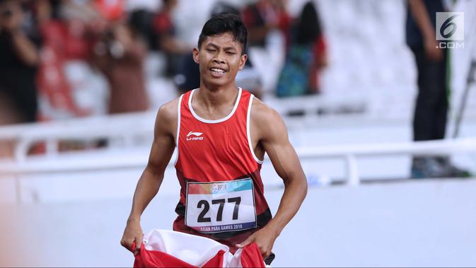 Atlet para-atletik Indonesia, Sapto Yogo Purnomo usai laga lari nomor 100 meter T37 pria yang  digelar di Stadion GBK, Jakarta, Selasa (9/10). Ini menjadi medali emas kedua Sapto di Asian Para Games 2018. (Liputan6.com/Helmi Fithriansyah)