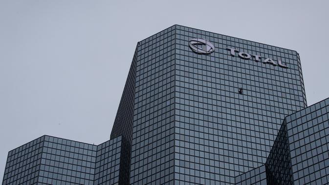 Pendaki Alain Robert atau French Spiderman memanjat Menara Total di kawasan bisnis La Defense, Paris, Prancis, Senin (13/1/2020). Alain memanjat gedung tersebut tanpa menggunakan tali pengaman. (Thomas SAMSON/AFP)