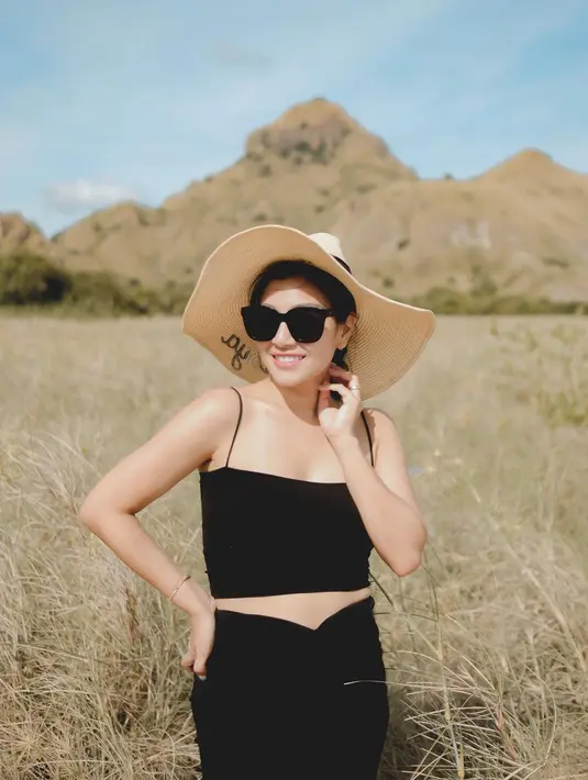 Nisya Ahmad berpose memakai crop tank top hitam serta rok mini memamerkan kulit mulusnya. Tak ketinggalan, kacamata hitam dan topi pun turut dikenakan agar lebih maksimal. Sambil berpose cantik di tengah rerumputan, Nisya Ahmad sukses mencuri perhatian. (Instagram/nissyaa)