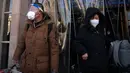 Para pemudik yang memakai masker dan pelindung wajah berjalan keluar Stasiun Kereta Api Beijing di Beijing, China, Sabtu (14/1/2023). Jutaan warga China diperkirakan akan melakukan perjalanan selama periode liburan Tahun Baru Imlek tahun ini. (AP Photo/Mark Schiefelbein)