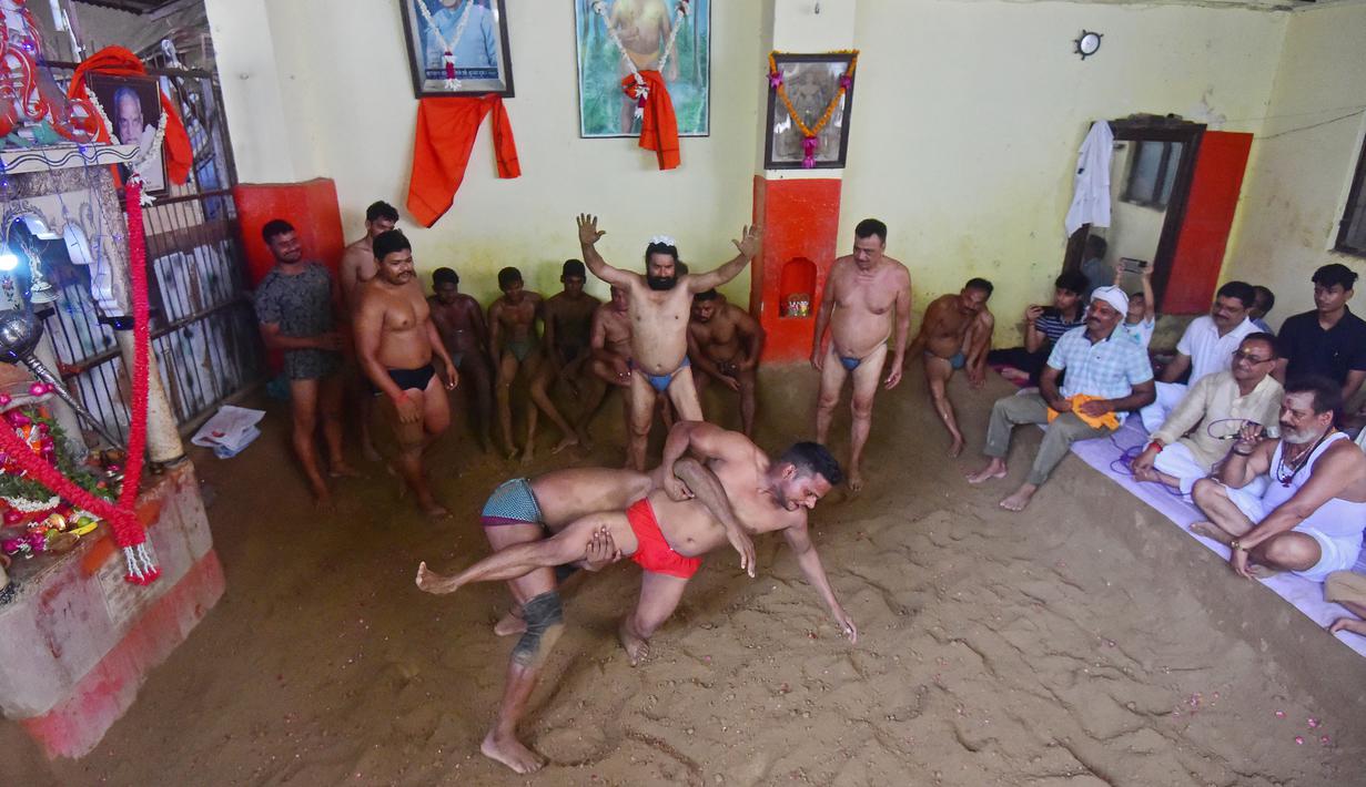 Pegulat beraksi dalam pertandingan gulat tradisional di klub gulat Loknath Vyayamsala di Prayagraj, India, (21/8/2023). Acara tersebut untuk merayakan festival Hindu Nag Panchami. (AFP/Sanjay kanojia)