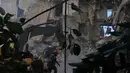 Dengan menggunakan 50 jet tempur, serangan Israel menghantam 100 target dalam waktu hanya 10 menit. Tampak dalam foto, para pekerja pertahanan sipil Lebanon dan sebuah ekskavator membersihkan puing-puing di lokasi bangunan yang hancur akibat serangan udara Israel sehari sebelumnya di pusat kota Beirut, Lebanon, Kamis 9 April 2026. (AP Photo/Hassan Ammar)