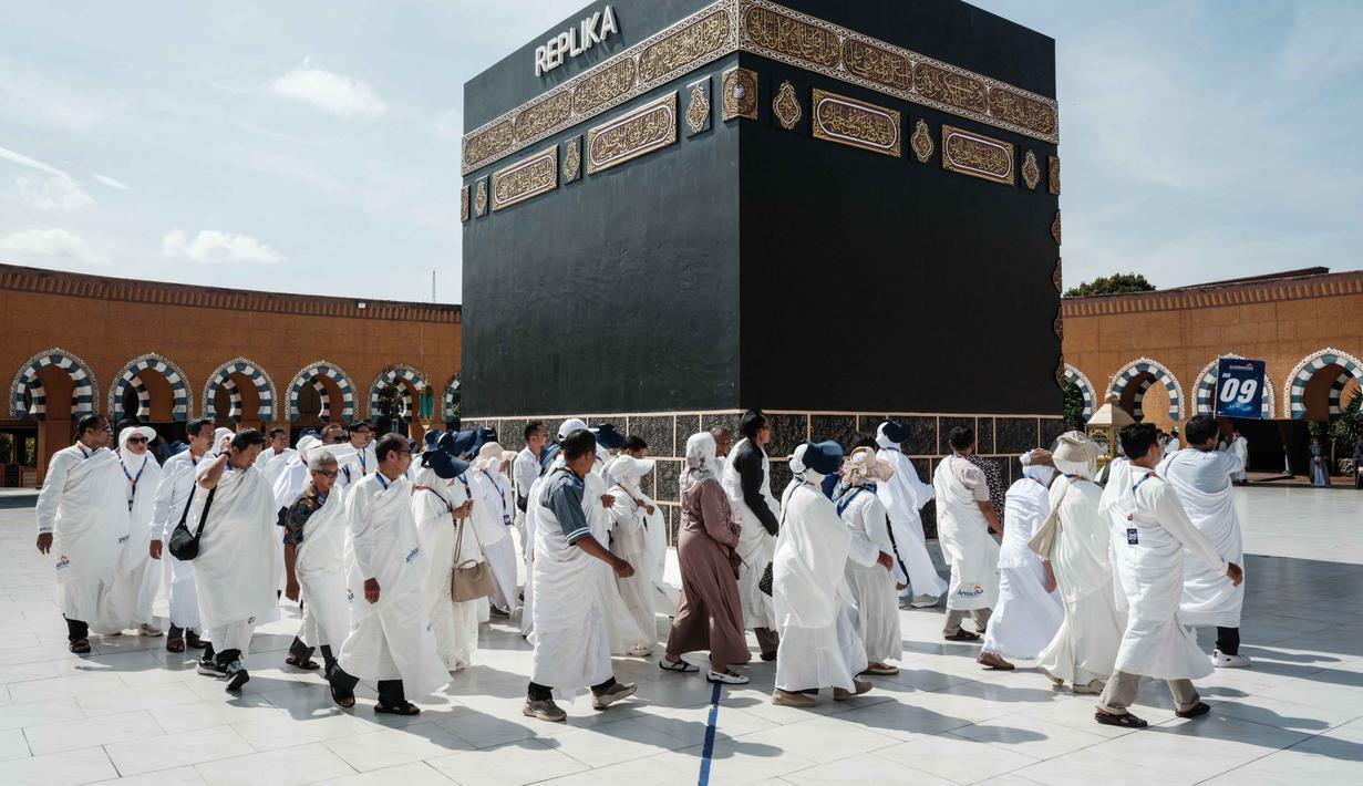 Penurunan biaya haji 2026 tetap dilakukan meski harga bahan bakar pesawat (avtur) sedang mengalami lonjakan signifikan. Tampak dalam foto, para calon jemaah haji Indonesia melakukan ritual tawaf mengelilingi replika Ka'bah, di Al Mahmudah Manasik Training Center (AMTC), sebuah fasilitas pelatihan haji yang menampilkan replika situs-situs ziarah utama, di Tangerang Selatan pada 5 April 2026. (YASUYOSHI CHIBA/AFP)