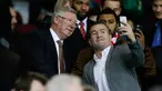 Mantan manajer Manchester United Sir Alex Ferguson berselfie dengan fans saat menyaksikan pertandingan antara Manchester United dengan Chelsea di Stadion Old Trafford, Inggris (28/12). MU bermain imbang dengan Chelsea dengan skor 0-0. (Reuters/Phil Noble)
