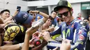 Valentino Rossi melayani tanda tangan penggemarnya setelah latihan bebas GP Malaysia di Sirkuit Sepang, Malaysia, (23/10/2015). (Reuters/Olivia Harris)