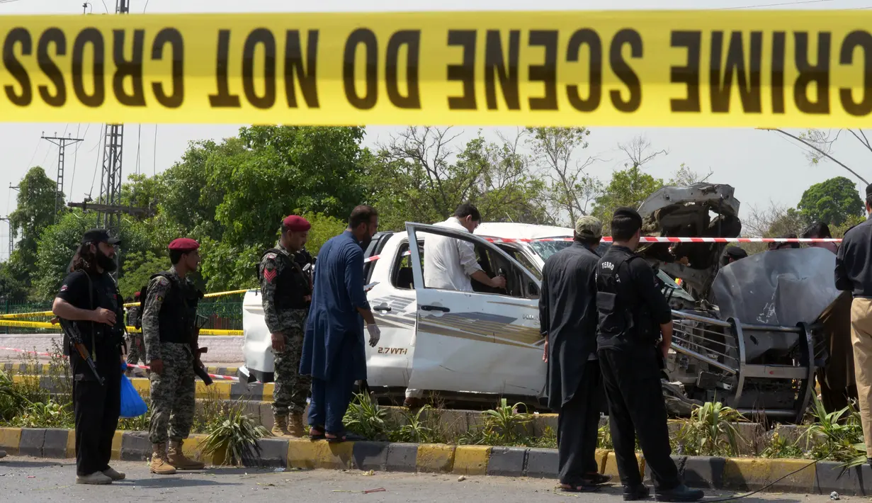 Garis polisi dipasang di lokasi serangan bom bunuh diri di Peshawar, Pakistan, Senin (17/7). Kejadian bom bunuh diri ini diklaim dilakukan oleh Taliban. (AFP Photo/Abdul Majeed)