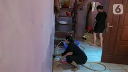 Warga pun mulai sibuk membersihkan rumah mereka dari endapan lumpur serta sisa sampah yang terbawa arus banjir. (Liputan6.com/Herman Zakharia)