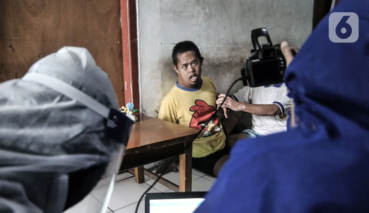 Petugas Disdukcapil Kota Jakarta Utara merekam E-KTP penyandang disabilitas di Pademangan Barat, Jakarta, Kamis (16/7/2020). Program jemput bola ini untuk memudahkan pelayanan administrasi kependudukan bagi penyandang disabilitas, jompo dan orang sakit di masa pandemi. (merdeka.com/Iqbal S. Nugroho)