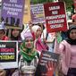 Sejumlah orang yang tergabung dalam beberapa aktivis membawa spanduk saat menggelar aksi unjuk rasa dikawasan Patung Kuda, Jakarta, Rabu (8/3). Peserta aksi menyuarakan penolakan terhadap diskriminasi dan sistem patriarki. (Liputan6.com/Faizal Fanani)
