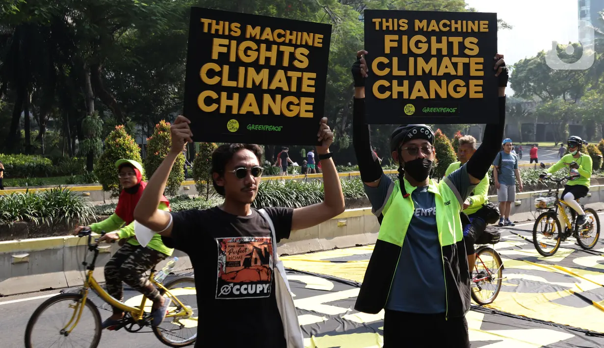 Aktivis Greenpeace dan Bike2Work membentangkan tulisan di Jalan Jenderal Sudirman, Jakarta, Minggu (5/6/2022). Aksi ini untuk memperingati Hari Lingkungan Hidup dan hari Sepeda Sedunia serta kampanye penggunaan sepeda sebagai kendaraan ramah lingkungan. (Liputan6.com/Helmi Fithriansyah)
