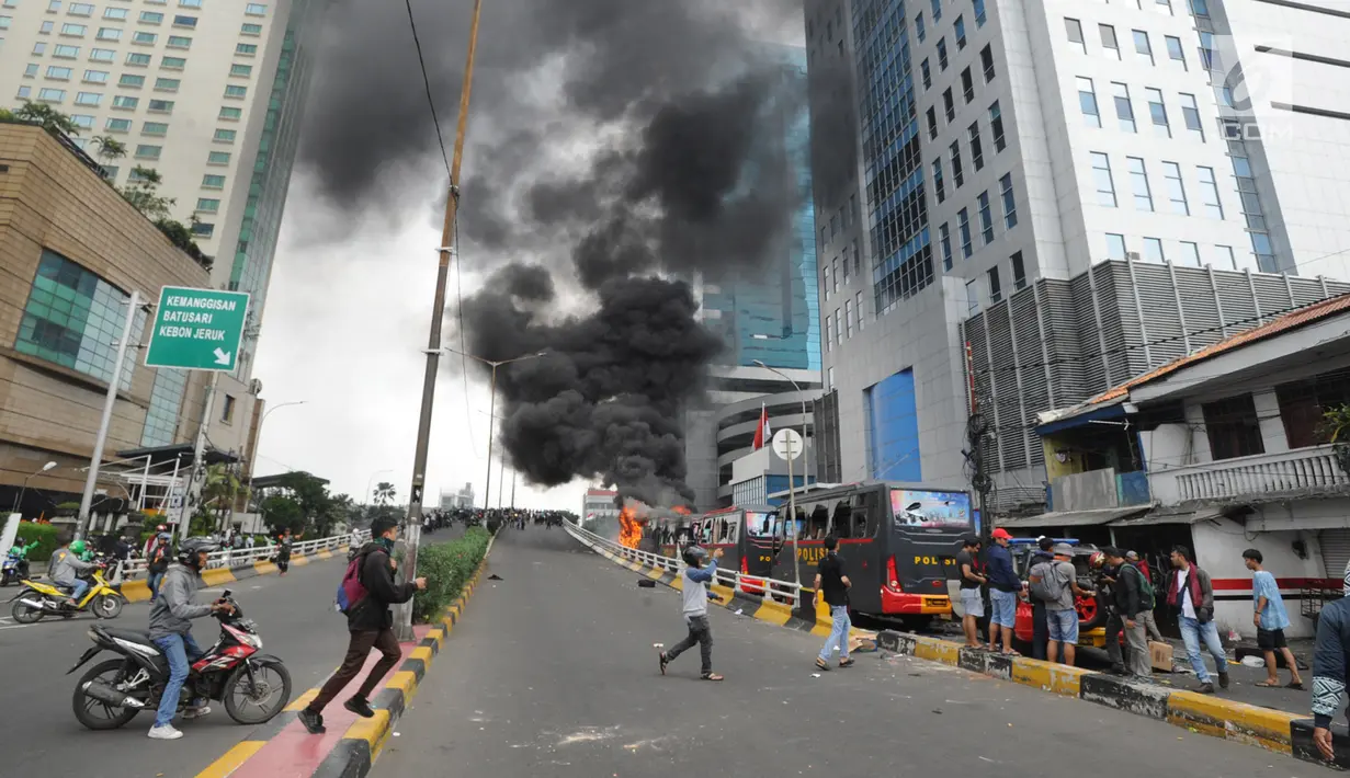 Sejumlah warga mendekati bus polisi yang terbakar di dekat Flyover Slipi, Palmerah, Jakarta Barat, Rabu (22/5/2019). Belum diketahui penyebab terbakarnya dua bus yang terparkir bersama bus polisi lainnya dilokasi tersebut. (merdeka.com/Arie Basuki)