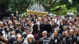 Prosesi ini diikuti oleh ribuan peziarah yang menggunakan ratusan kapal motor, sampan kecil, dan perahu nelayan yang memenuhi selat Larantuka. Tampak dalam foto, umat Katolik mengangkut peti mati berisi patung Yesus selama prosesi laut Jumat Agung dari Kapel Tuan Menino, sebuah ritual yang diwarisi dari pengaruh Portugis selama lebih dari lima abad, di Larantuka, Nusa Tenggara Timur, pada Jumat 3 April 2026. (ARNOLD WELIANTO/AFP)