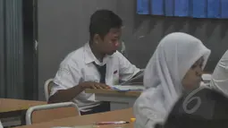 Seorang pelajar tampak tengah mengerjakan soal Ujian Nasional (UN) di SMPN 29 Jakarta, Senin (5/4/2015). UN tingkat SMP tersebut diikuti 149.172 peserta. (Liputan6.com/Johan Tallo)