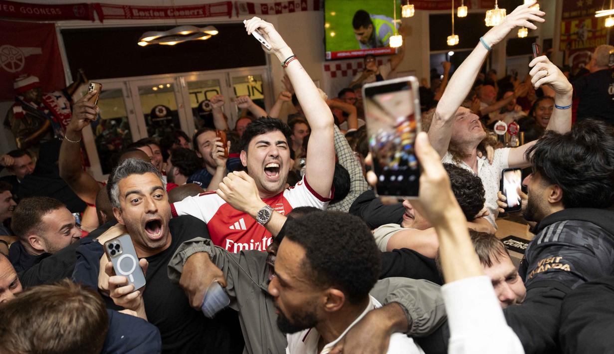 Para penggemar Arsenal merayakan kemenangan tim mereka di Liga Primer Inggris, dari dalam pub Tollington Arms dekat Stadion Emirates, London, Inggris, pada 19 Mei 2026. (Brook Mitchell/AFP)