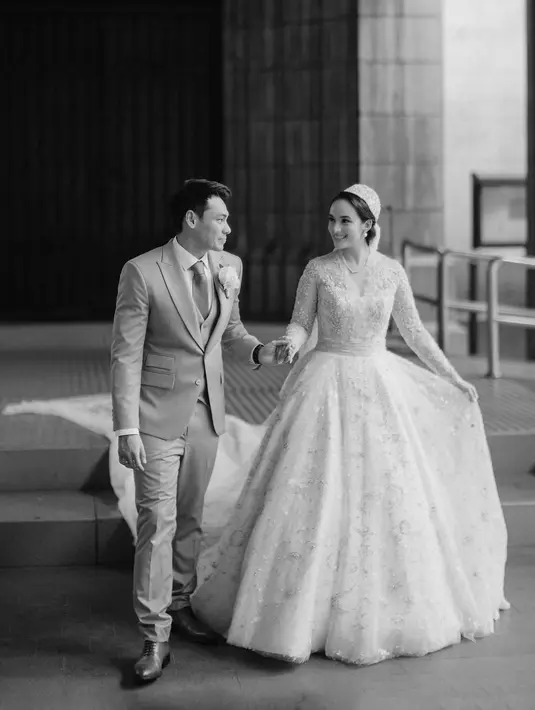 Gaun rancangan Biyan Wanaatmadja tersebut bergaya klasik dengan ball gown dan train dengan juliet cap veil yang panjang [@iluminen]