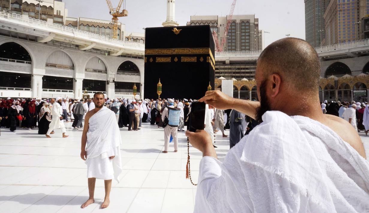 Jemaah berpose di depan Ka'bah selama umrah di Masjidil Haram, Makkah, Arab Saudi, Senin (2/3/2020).  Kementerian Kesehatan Arab Saudi telah mengumukan pada Senin 2 Maret 2020 telah menemukan adanya kasus Virus Corona pertama warga negara Saudi yang kembali dari Iran melalui Bahrain. (AP Photo/Amr N