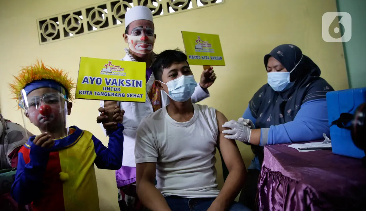 Seorang warga ditemani badut saat mengikuti vaksinasi COVID-19 di Pinang, Tangerang, Banten, Selasa (14/9/2021). Aksi yang dilakukan Taman Baca Badut Syariah itu dilakukan untuk mengajak warga mengikuti vaksinasi COVID-19 guna meningkatkan herd imunity. (Liputan6.com/Angga Yuniar)