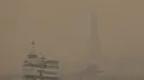 Asap dari kebakaran hutan yang terjadi ratusan mil di utara Kanada mengirimkan kabut asap ke seluruh kota, membuat Patung Liberty dan cakrawala ikonik itu sulit dilihat dari jarak dekat sekalipun. (AP Photo/Yuki Iwamura)
