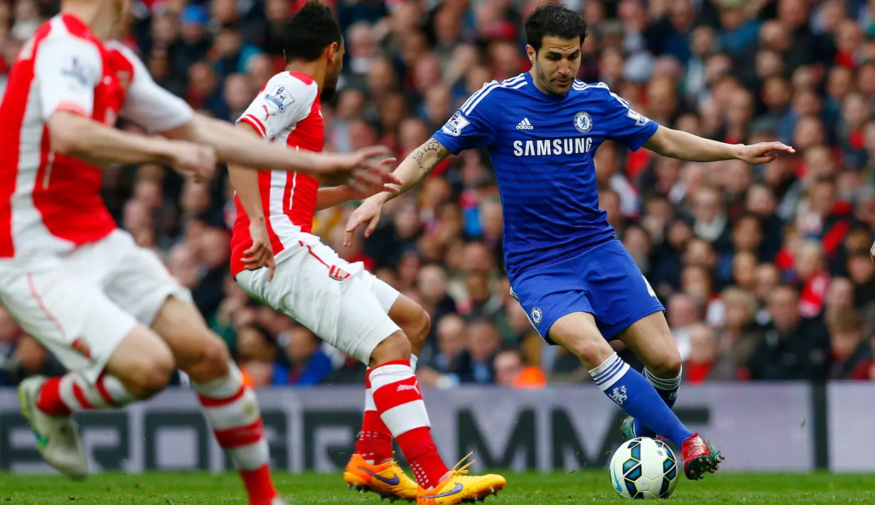 Gelandang Chelsea,  Cesc Fabregas (kanan) berusaha melewati dua pemain Arsenal saat Laga Liga Premier Inggris di Emirates Stadium, Minggu (26/4/2015). Arsenal bermain imbang 0-0 atas Chelsea. (Reuters/Eddie Keogh)