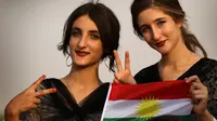 Dua gadis Kurdi Iran berpose saat mengampanyekan referendum untuk kemerdekaan di kota Bahirka, Irak Utara (21/9). Referendum kemerdekaan yang akan diselenggarakan Pemerintah Regional Kurdistan (KRG) akan di gelar pada 25 September. (AFP Photo/Safin Hamed)