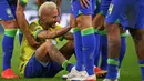 Pemain Brasil, Neymar dihibur oleh rekan-rekannnya setelah tim mereka kalah dari Kroasia saat laga perempat final Piala Dunia Qatar 2022 yang berlangsung di Education City Stadium, Al-Rayyan, Jumat (09/12/2022) waktu setempat. Brasil kalah 2-4 dari Kroasia saat babak adu penalti. (AFP/Adrian Dennis)