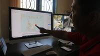 Seorang staf Stasiun Geofisika Kelas I Palu sedang menunjuk peta kegempaan di Sulteng. Sepanjang 2019 terjadi 1.099 gempa bumi wilayah tersebut. (Liputan6.com/ Heri Susanto)